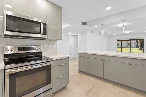 a kitchen with stainless steel appliances a stove microwave and cabinets