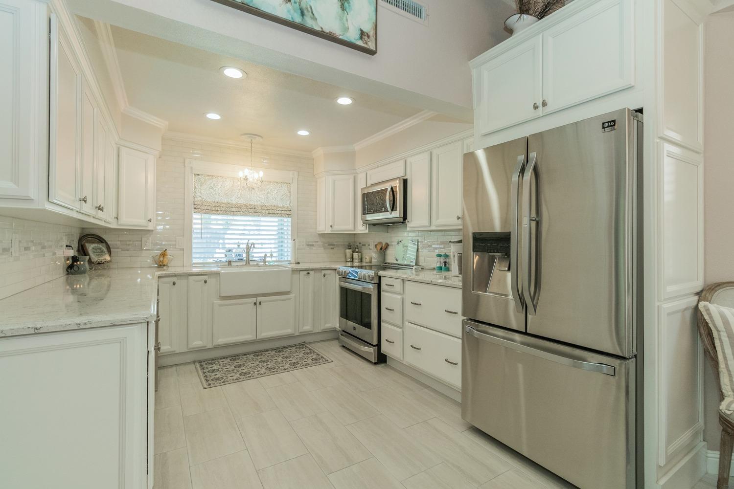 2508 Gibson Avenue Clovis, CA 93611 - Photo 10 of 33 a kitchen with white cabinets and stainless steel appliances