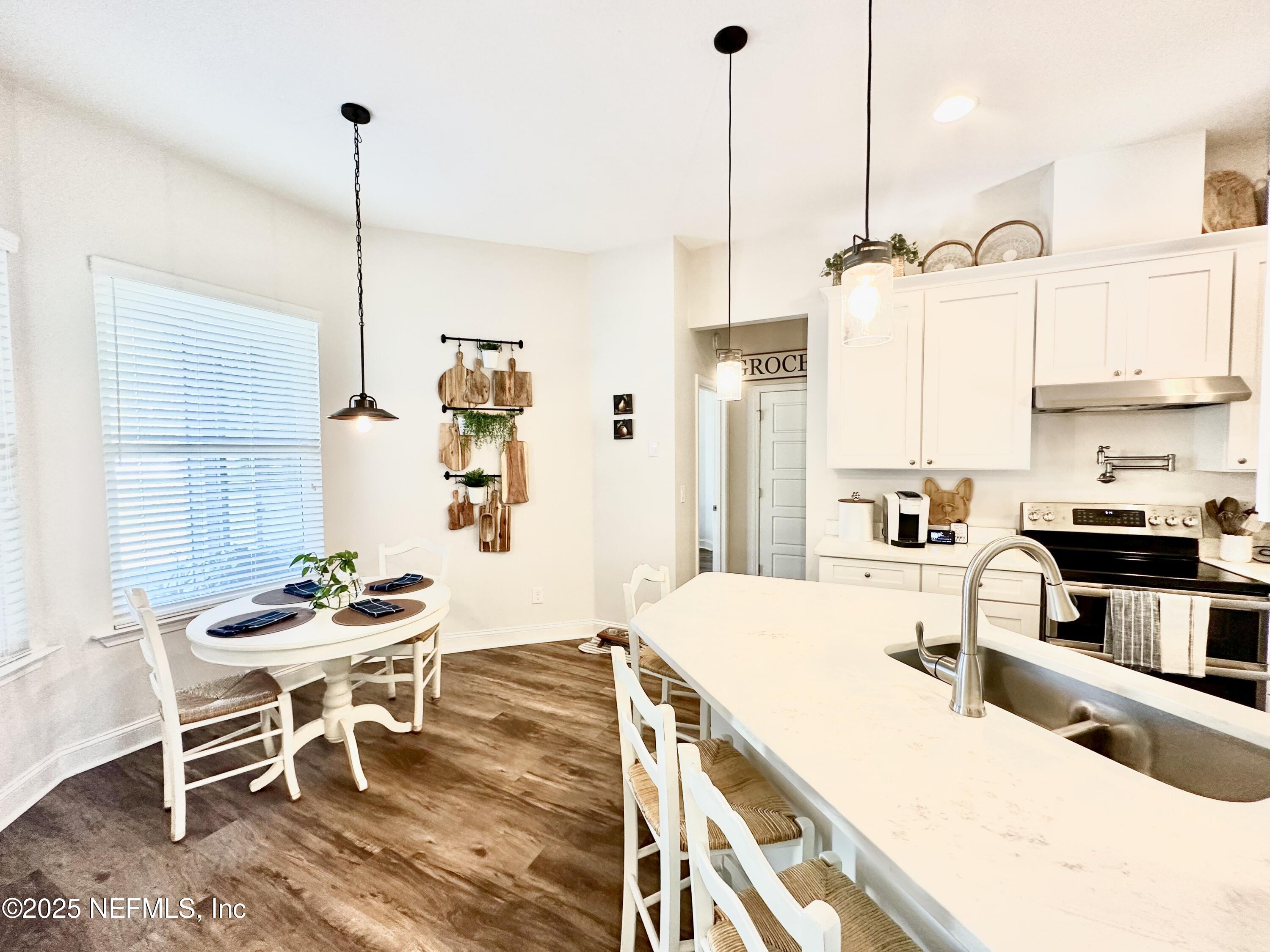55370 Deer Run Road Callahan, FL 32011 - Photo 13 of 44 a kitchen with stainless steel appliances kitchen island granite countertop a table chairs in it and white cabinets