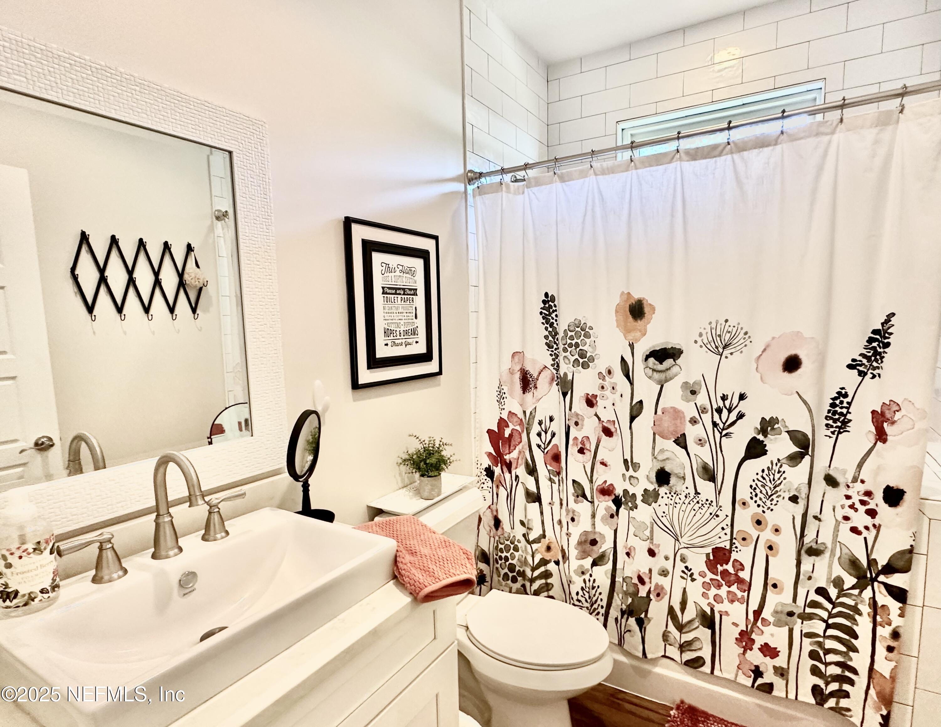 55370 Deer Run Road Callahan, FL 32011 - Photo 24 of 44 a bathroom with a sink a toilet and shower curtain