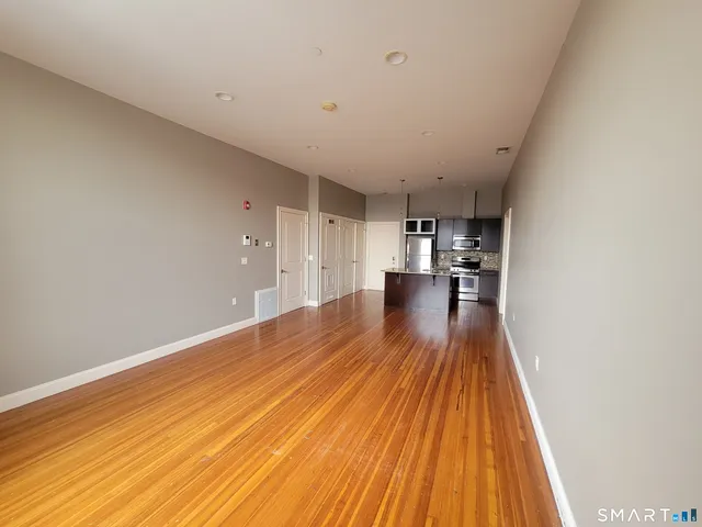 a view of empty room with wooden floor