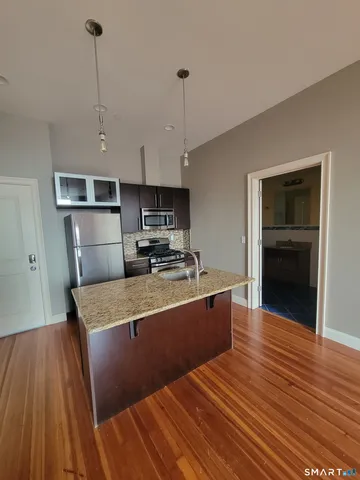 a kitchen with stainless steel appliances granite countertop a sink stove and wooden floor