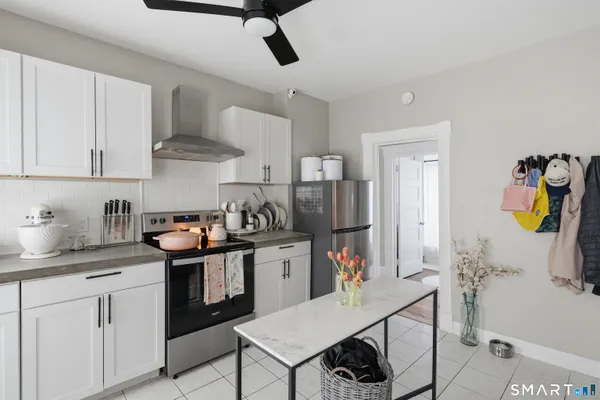 a kitchen with stainless steel appliances granite countertop a sink a stove and a refrigerator