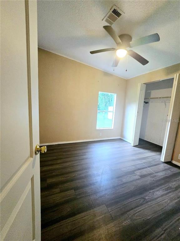 208 Pine Tree Trail Crescent City, FL 32112 - Photo 14 of 16 an empty room with wooden floor and windows