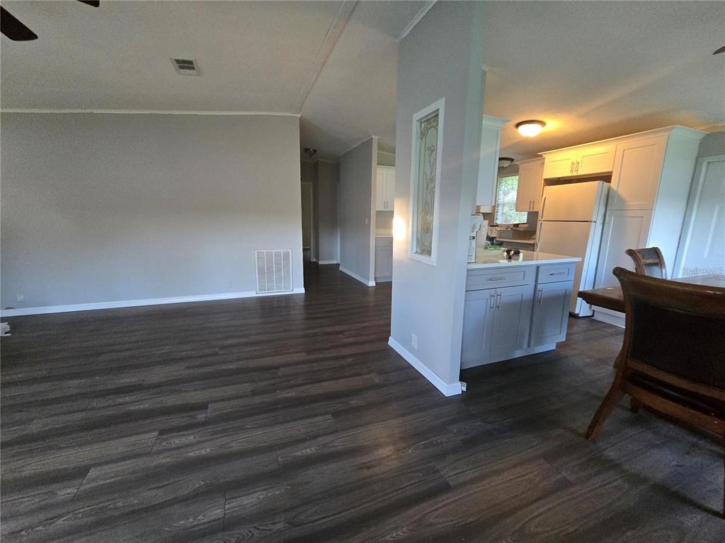 208 Pine Tree Trail Crescent City, FL 32112 - Photo 4 of 16 a view of kitchen and living room with wooden floor