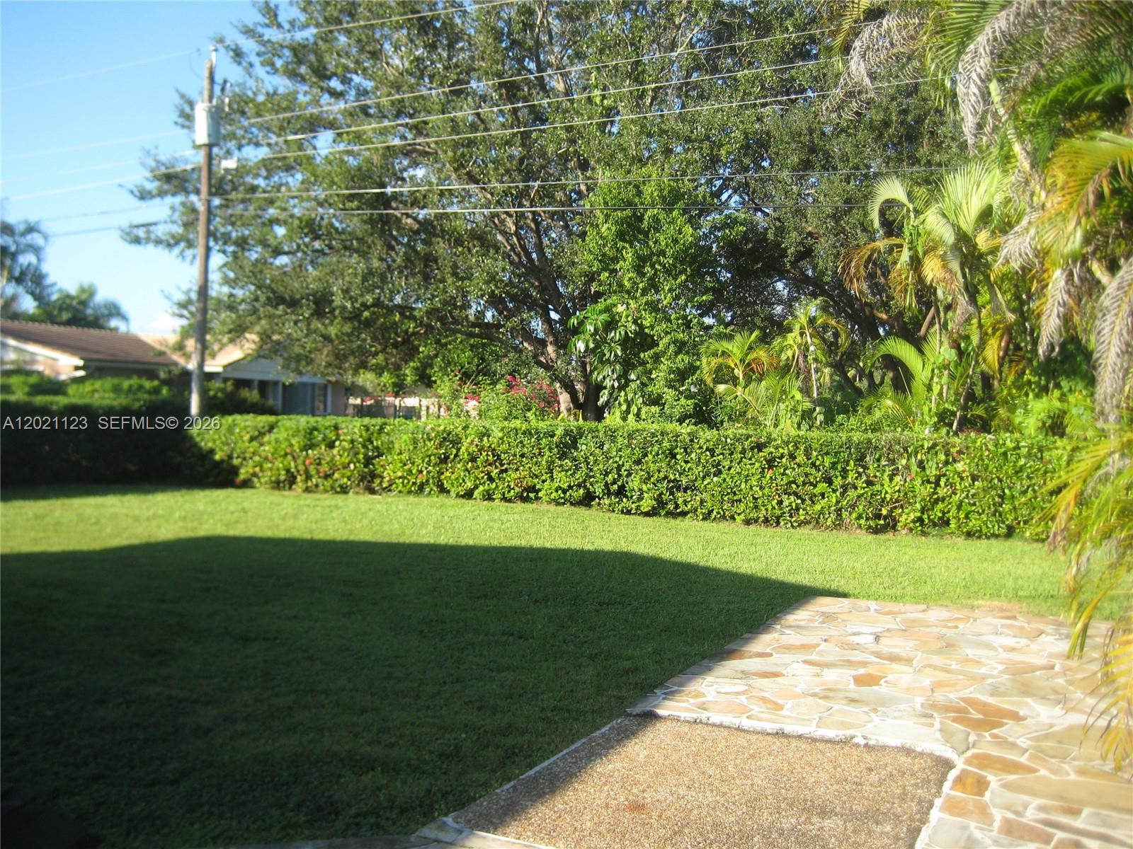 13220 Southwest 99th Place Miami, FL 33176 - Photo 15 of 16 a view of a garden with a bench
