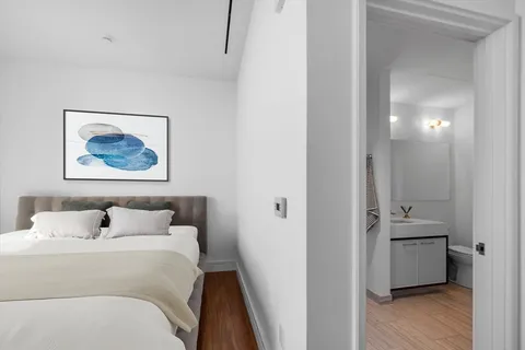 a bedroom with a bed and a painting on the wall