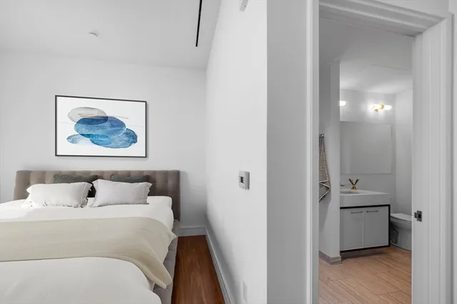 a bedroom with a bed and a painting on the wall