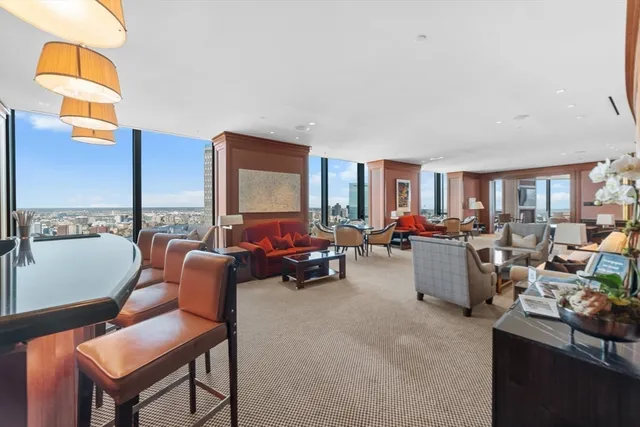 a living room with furniture kitchen view and a large window