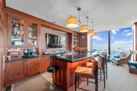 a kitchen with stainless steel appliances granite countertop a stove and a view of living room