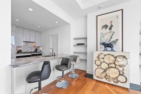 a kitchen with granite countertop cabinets a dining table and chairs with wooden floor