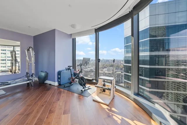 a living room with furniture a wooden floor and a large window