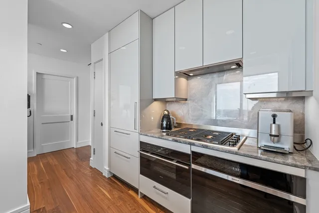 a kitchen with stainless steel appliances a stove and wooden floor