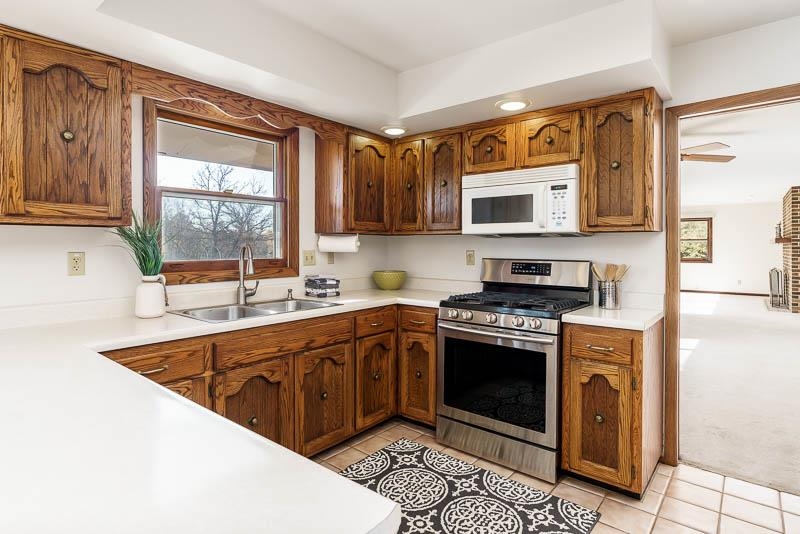 11371 Corrigan Road Roscoe, IL 61073 - Photo 20 of 85 a kitchen with stainless steel appliances granite countertop a stove a sink and a microwave