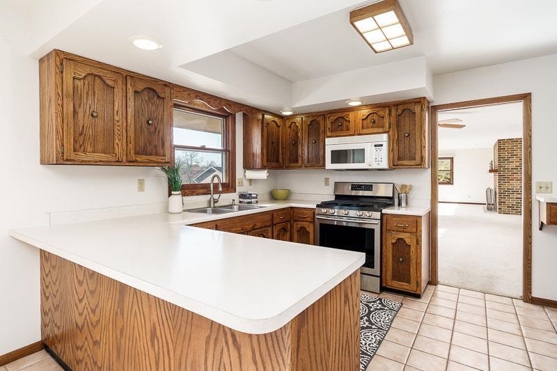 11371 Corrigan Road Roscoe, IL 61073 - Photo 21 of 85 a kitchen with stainless steel appliances granite countertop a stove a sink and a refrigerator
