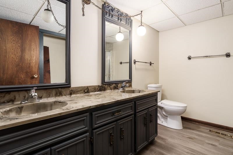 11371 Corrigan Road Roscoe, IL 61073 - Photo 40 of 85 a bathroom with a granite countertop sink a toilet and a mirror