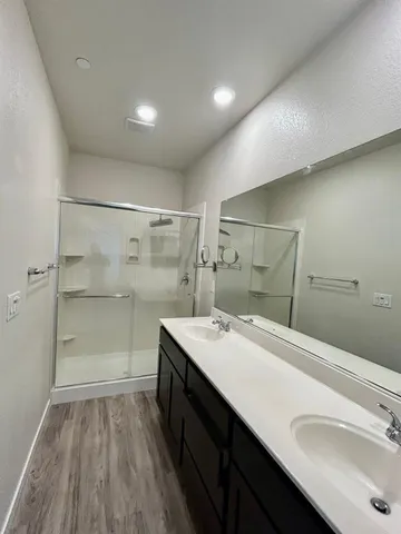 a bathroom with a sink a toilet a large mirror and shower