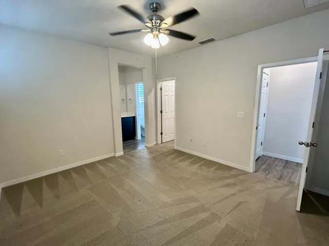 an empty room with closet and a chandelier fan