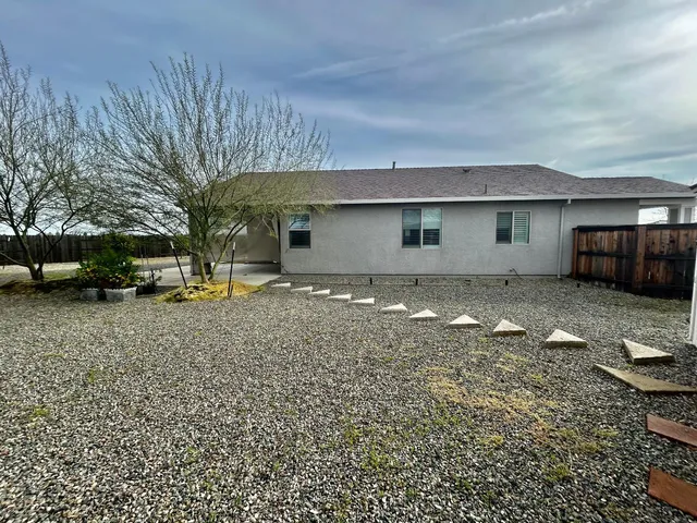a backyard of a house with parked cars
