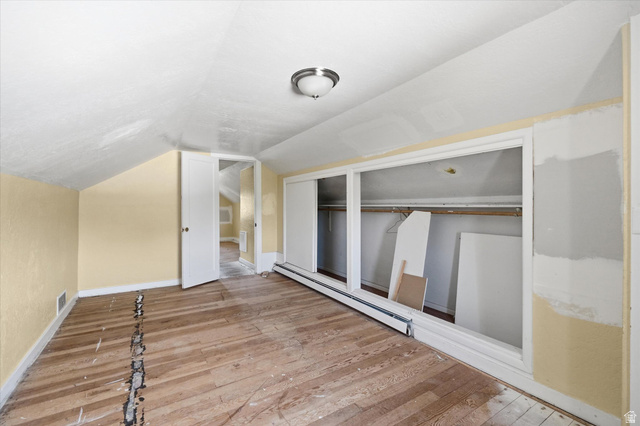 395 North 400 West Logan, UT 84321 - Photo 15 of 48 Room featuring a sloped ceiling, wood-finish flooring, and built-in closet space with sliding doors