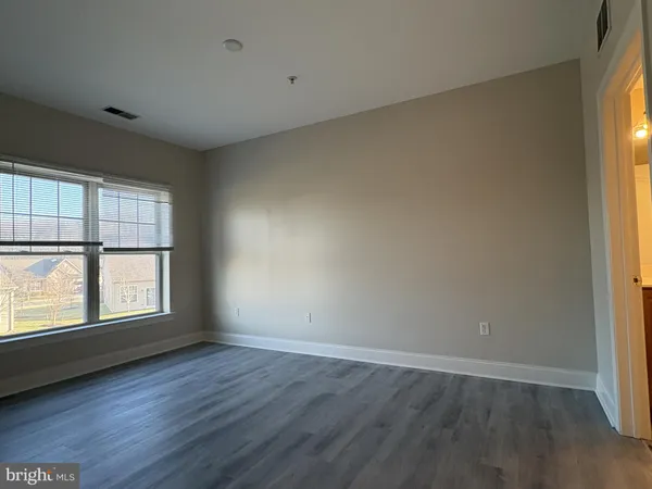 a view of empty room with wooden floor and cabinet