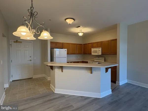 a kitchen with stainless steel appliances granite countertop a sink a stove top oven a counter space and cabinets