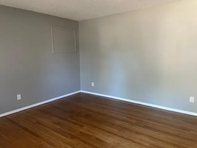 a view of an empty room with wooden floor