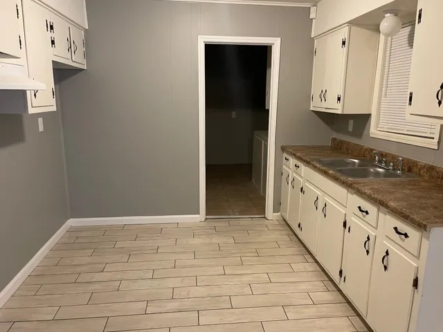 a view of a kitchen with granite countertop white cabinets