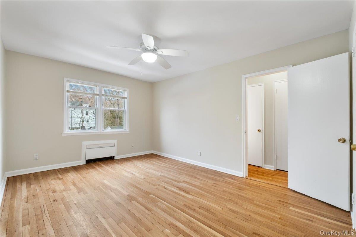 15 Chestnut Street, Unit 6A Rye, NY 10580 - Photo 11 of 27 an empty room with wooden floor chandelier fan and windows