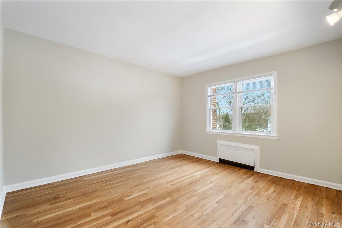 15 Chestnut Street, Unit 6A Rye, NY 10580 - Photo 20 of 27 a view of an empty room with wooden floor and a window