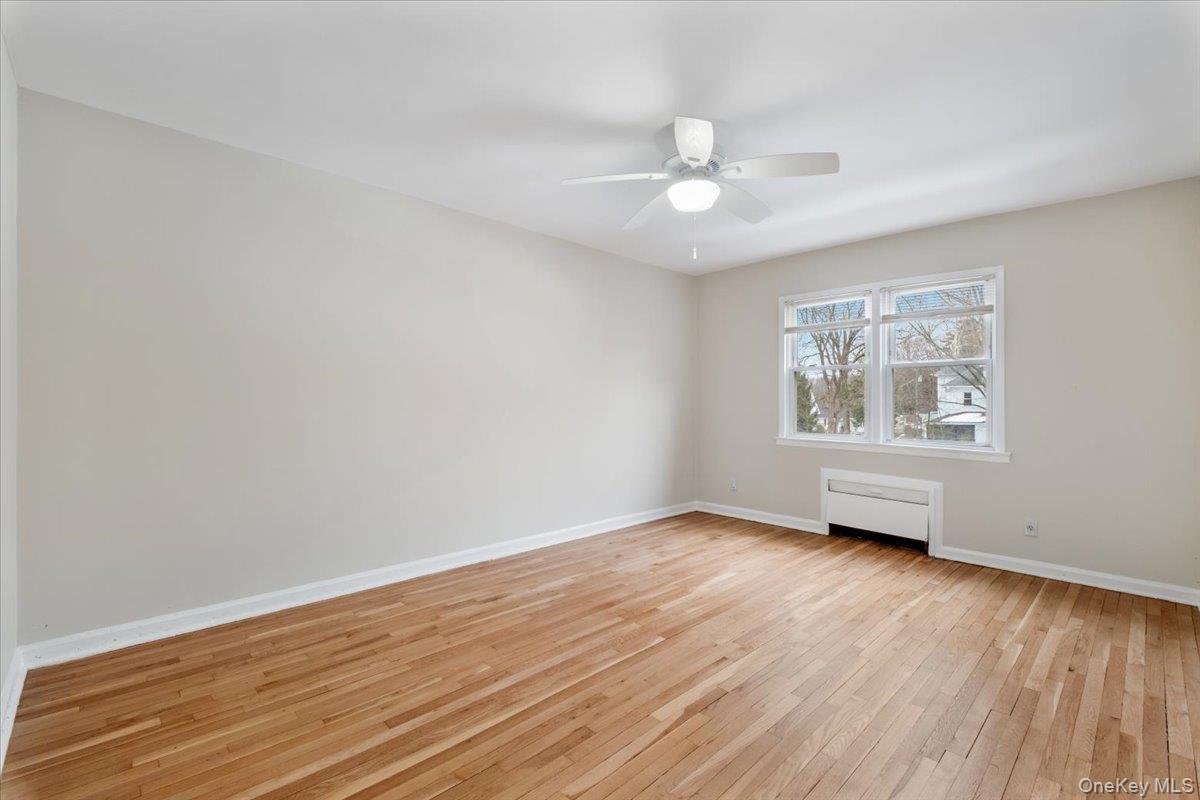 15 Chestnut Street, Unit 6A Rye, NY 10580 - Photo 10 of 27 an empty room with wooden floor chandelier fan and windows