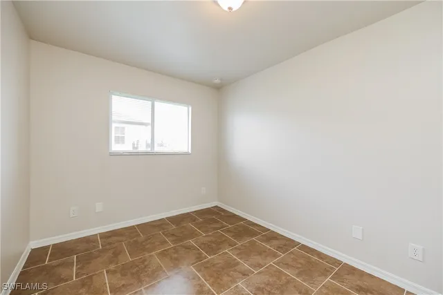an empty room with a white wall and a window