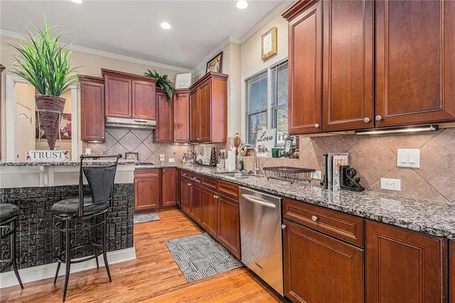 a kitchen with stainless steel appliances granite countertop a stove a sink and a microwave