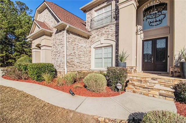front view of a brick house with potted plants