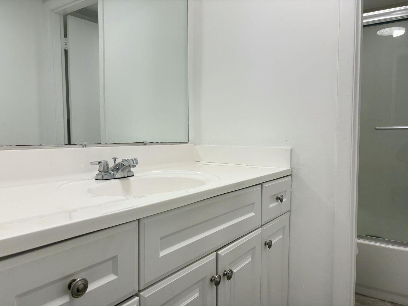 642 Northwest 13th Street, Unit 210 Boca Raton, FL 33486 - Photo 13 of 17 a bathroom with a sink and a mirror