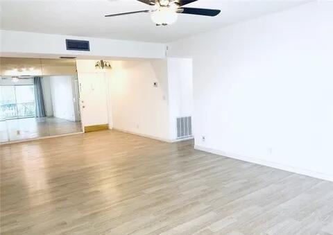 642 Northwest 13th Street, Unit 210 Boca Raton, FL 33486 - Photo 6 of 17 an empty room with wooden floor and windows
