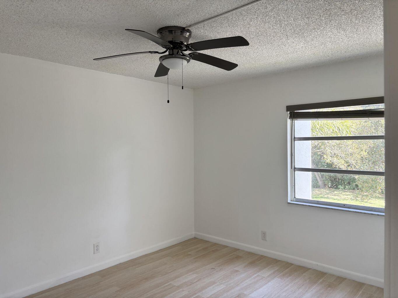642 Northwest 13th Street, Unit 210 Boca Raton, FL 33486 - Photo 10 of 17 an empty room with a window and a ceiling fan