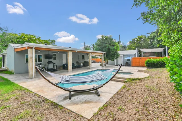 a view of house with swimming pool and sitting area