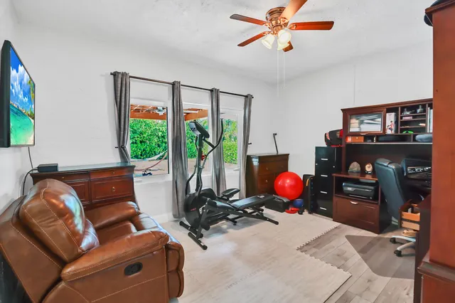 a living room with furniture a flat screen tv and a window