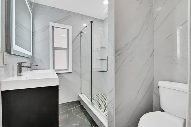 a bathroom with a sink toilet and shower