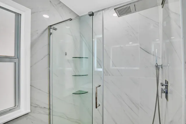 a bathroom with a shower and a glass door