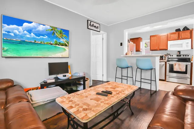 a living room with furniture a rug and a flat screen tv