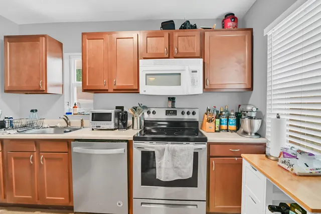 a kitchen with stainless steel appliances granite countertop a sink stove and cabinets