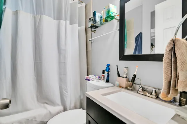 a bathroom with a sink vanity mirror and toilet