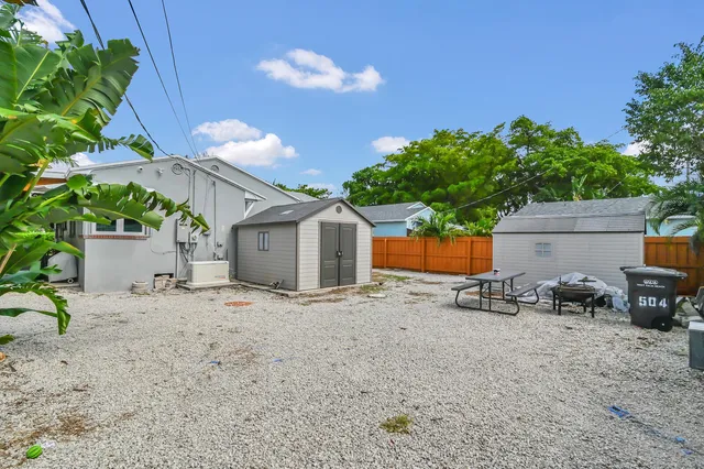 a backyard of a house with table and chairs