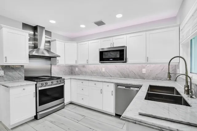 a kitchen with granite countertop a stove sink and microwave