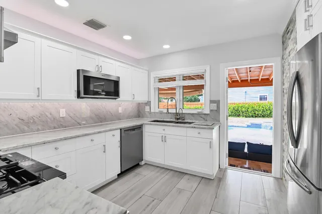 a kitchen with granite countertop a refrigerator and a sink