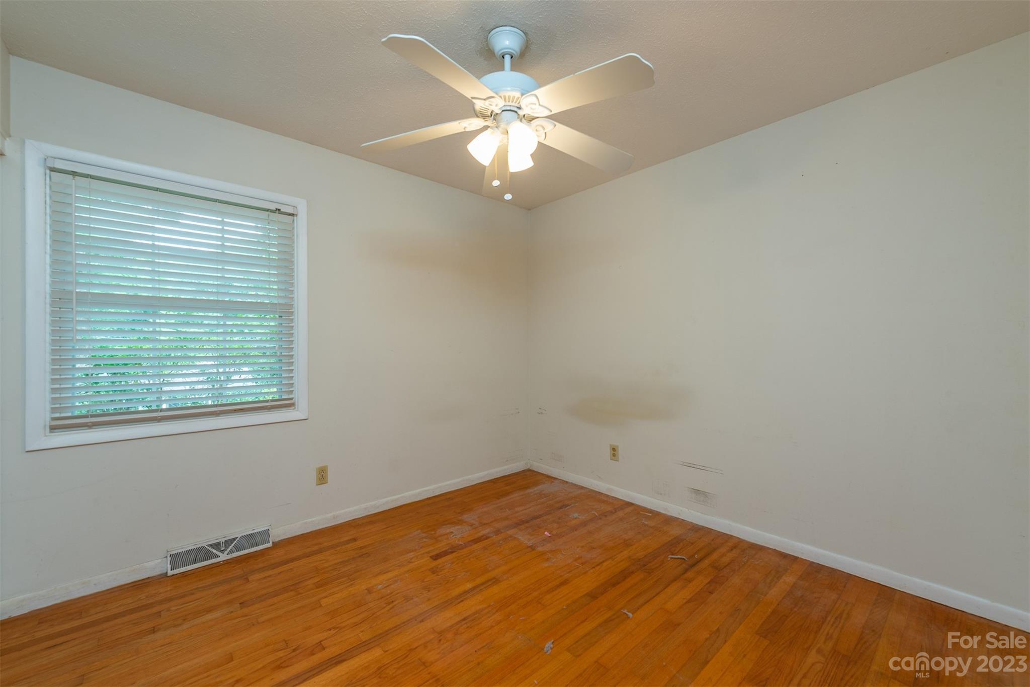 92 Alpine Way Asheville, NC 28805 - Photo 10 of 22 an empty room with a chandelier fan and windows