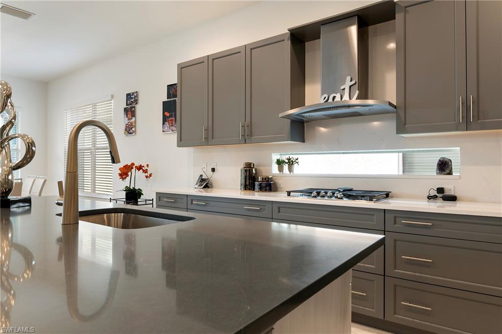 11488 Coronado Way Naples, FL 34120 - Photo 11 of 50 a kitchen with kitchen island granite countertop a sink stainless steel appliances and cabinets