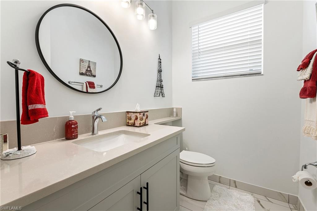 11488 Coronado Way Naples, FL 34120 - Photo 26 of 50 a bathroom with a toilet a sink a mirror and a window